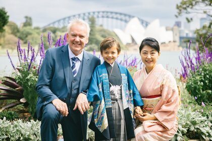 Das Foto zeigt Axel Becker mit seiner Familie. Im Hintergrund ist eine Stadt zu sehen.